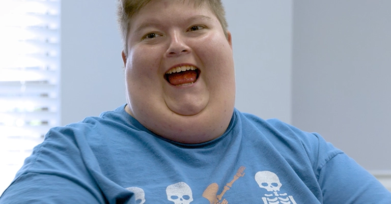 smiling child with pws in blue shirt