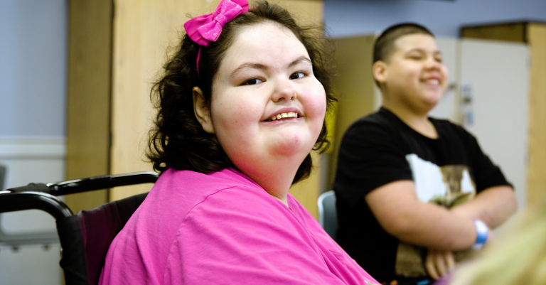 young girl with pws in a pink shirt