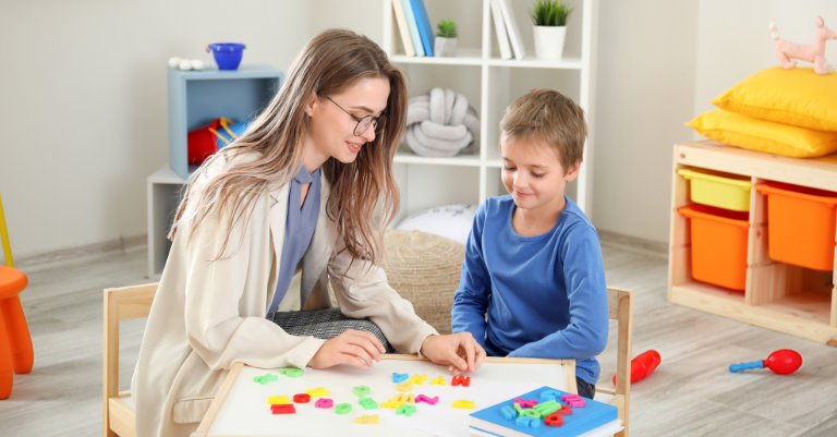 Young boy and therapist playing with letter magnets